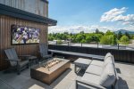 Rooftop with outdoor TV, fire table and lounge area. 